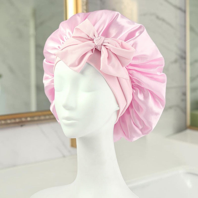 Gorro de satén rosa zafiropulse PERENNE Silk Slumber con lazo decorativo sobre maniquí para cuidado del cabello