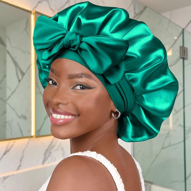 Modelo sonriente con gorro de satén verde esmeralda PERENNE Silk Slumber de zafiropulse con lazo decorativo